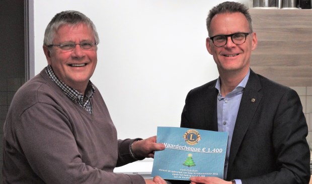 Hans Mostert (links) neemt met zichtbaar plezier de cheque in ontvangst. Rechts Eric Boer van Lions Club Delft.