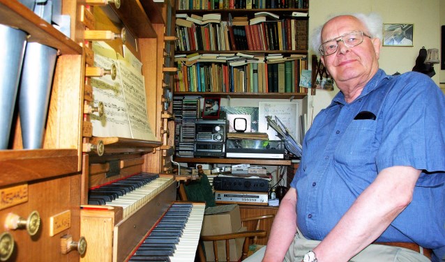 Jan J. van den Berg in zijn eigen woning, achter zijn zelfgebouwde orgel.