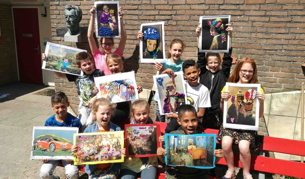 Leerlingen van de Simon Carmiggeltschool tonen hun kunstwerken.