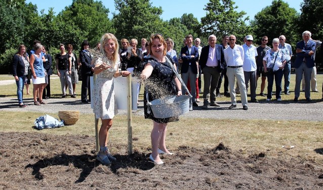 Deborah Post en wethouder Ilona Jense van de gemeente Pijnacker/Nootdorp strooien bloemzaad bij begraafplaats Sint Janshof