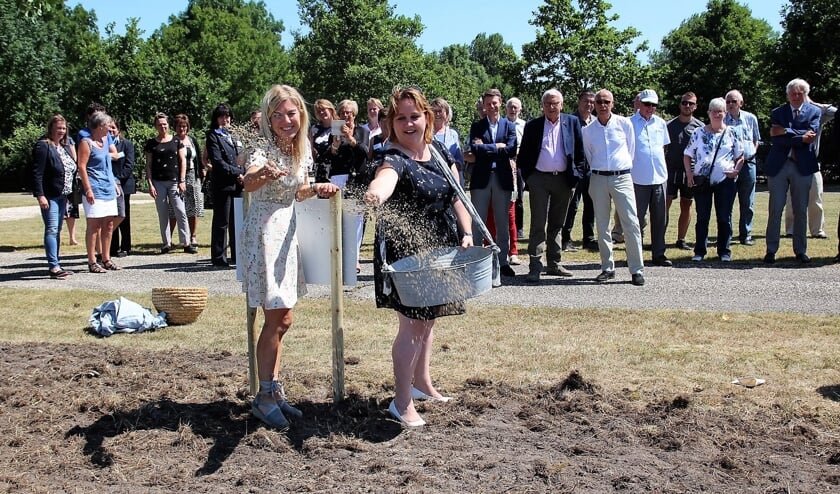 Deborah Post en wethouder Ilona Jense van de gemeente Pijnacker/Nootdorp strooien bloemzaad bij begraafplaats Sint Janshof
