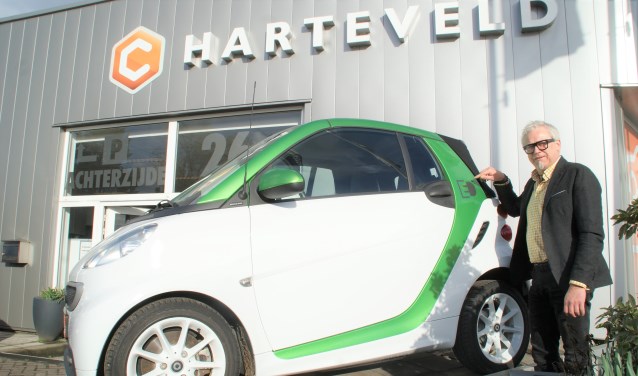 Directeur Leo Harteveld toont de Smart Fortwo Electric Drive bij de entree van zijn autobedrijf.