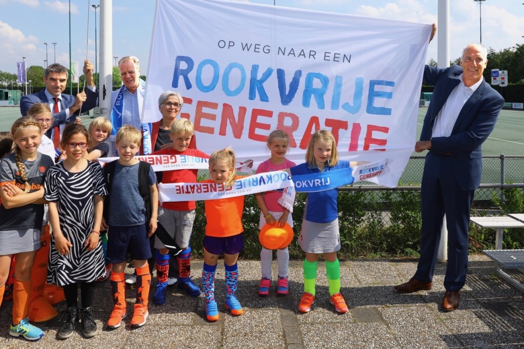 Voorzitter Peter van Haagen van Ring Pass showt, samen met de kleinste leden,vol trots de slogan. Ring Pass is de 1000e rookvrije sportvereniging in Nederland (Foto: Koos Bommelé)