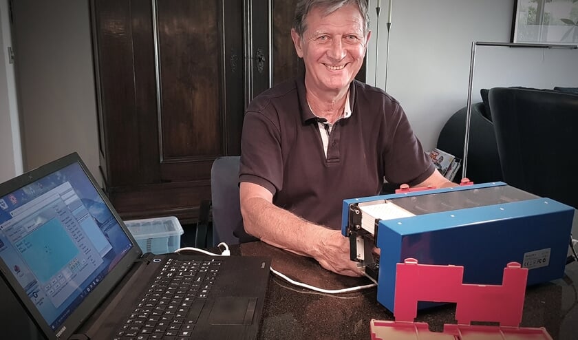 Peter Bommele, voorzitter van de Delftse bridgevereniging Gisolf bij een kaartdeelautomaat.