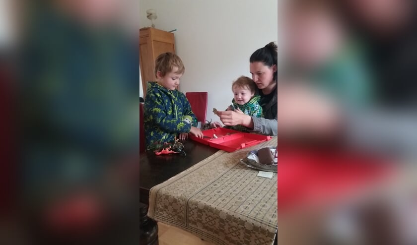 Jelle, Gijs en Janneke bekijken de inhoud van het koffertje