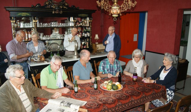 Een deel van de vrijwilligers die hebben bijgedragen aan de totstandkoming van het museumcafé poseren voor de historische tapkast
