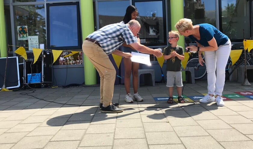 Theo Sijbers (links), met de oudste en jongste leerlingen van de school en directeur Simone Wolthuis (rechts).