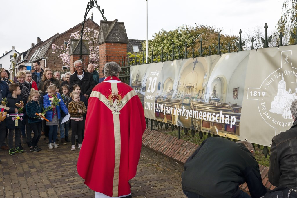 De onthulling van een grote banner aan het hek van de kerk.