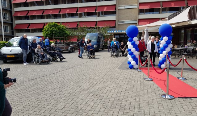 Deelnemende senioren lopen over de rode loper op weg naar "hun" oldtimer, foto: Toon van Cranenbroek