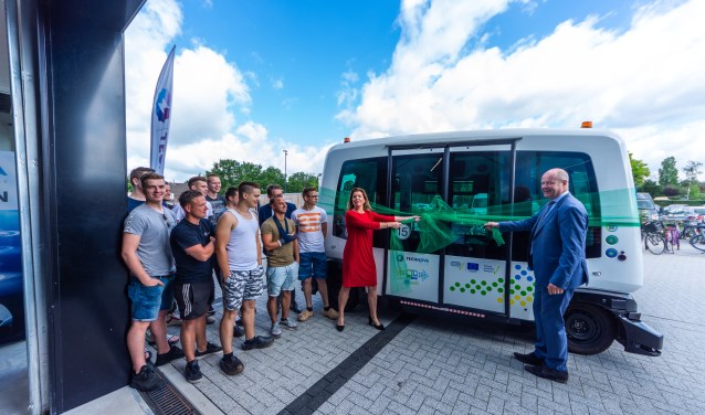 Studenten motorvoertuigentechniek, Christianne van der Wal, gedeputeerde van de provincie Gelderland en Jan Jacob van Dijk, voorzitter College van Bestuur van stichting COG.