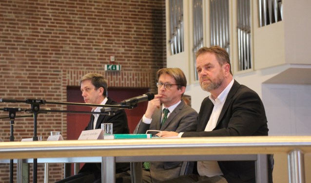 Leden van de bezwarencommissie luisteren in de Ontmoetingskerk naar de bezwaarmakers.