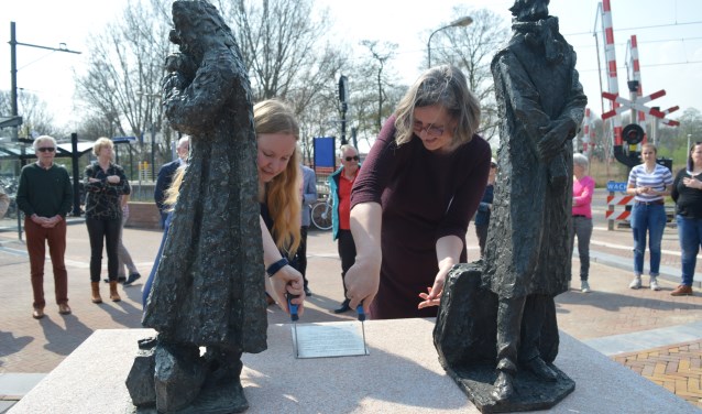De wethouders Schippers (links) en Van der Wal in de weer met het bevestigen van de plaquette. (foto en tekst Nicole Lamers)