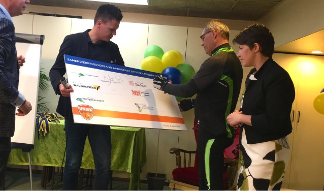 Wethouder Jan Verbeek tekent in sportieve outfit voor betere sportmogelijkheden voor mensen met een beperking.