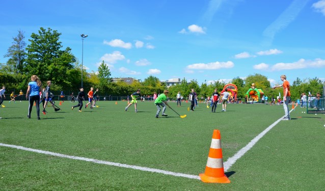 Leerlingen van De Wingerd, de Gideonschool en de PWA-school spelen in gemengde teams een potje hockey.