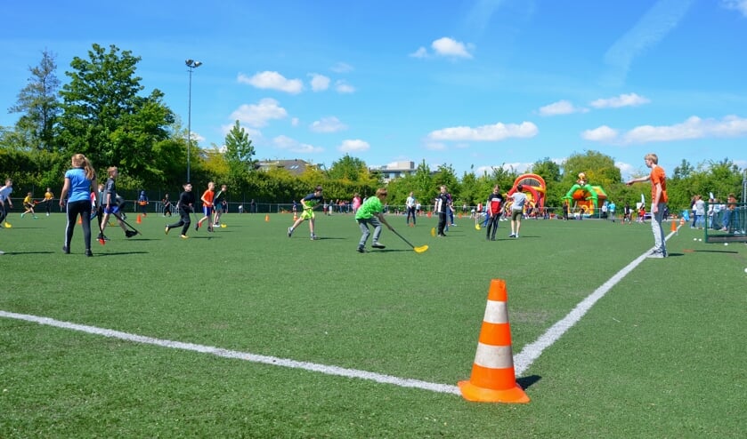 Leerlingen van De Wingerd, de Gideonschool en de PWA-school spelen in gemengde teams een potje hockey.