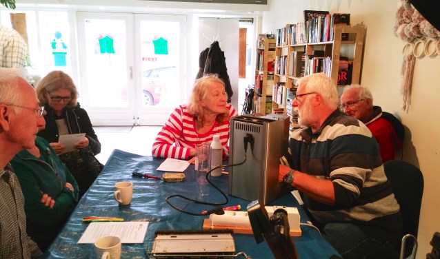 SAZ-klusser Nico de Weerd uit Nieuwerkerk doet zijn best om een espressomachine weer aan de praat te krijgen. (foto en tekst: Judith Rikken)