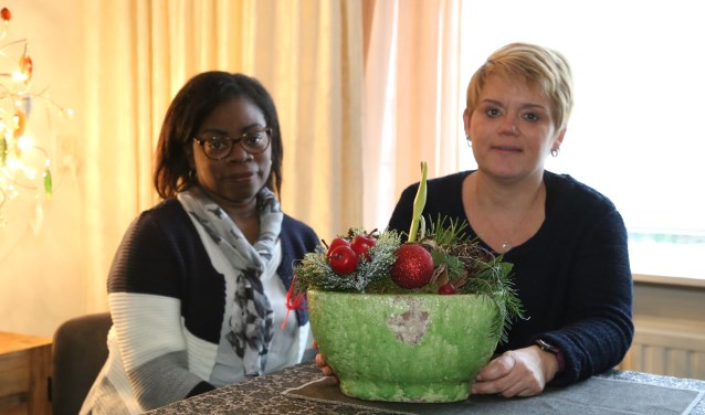 Tamara (r.) en buddy Jacqueline, met het kerststukje dat zij samen maakten. | Fotonummer: 18e3d0