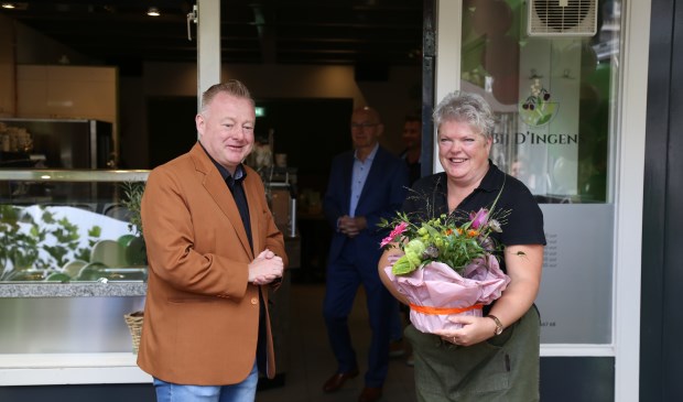Ingrid van Veen neemt uit handen van wethouder Eric van den Broek een felicitatiegeschenk in ontvangst bij de opening van haar nieuwe zaak aan de Markt in Boxtel. | Fotonummer: f3b606