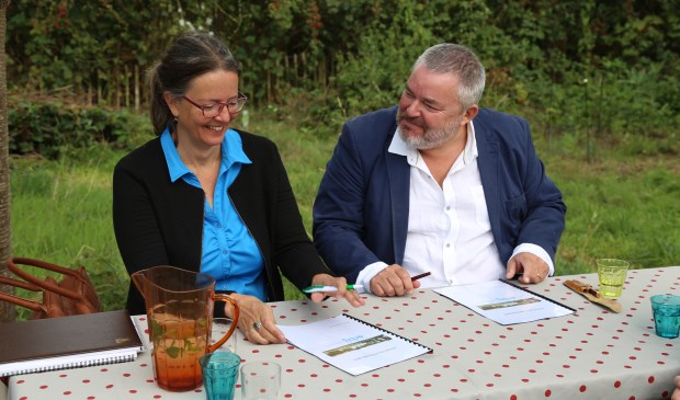 Patricia van Rooij (l.) van Kleine Aarde Netwerk en Rick Spooren van Erbij Dagbesteding ondertekenen de intentieverklaring. | Fotonummer: c5bb6f