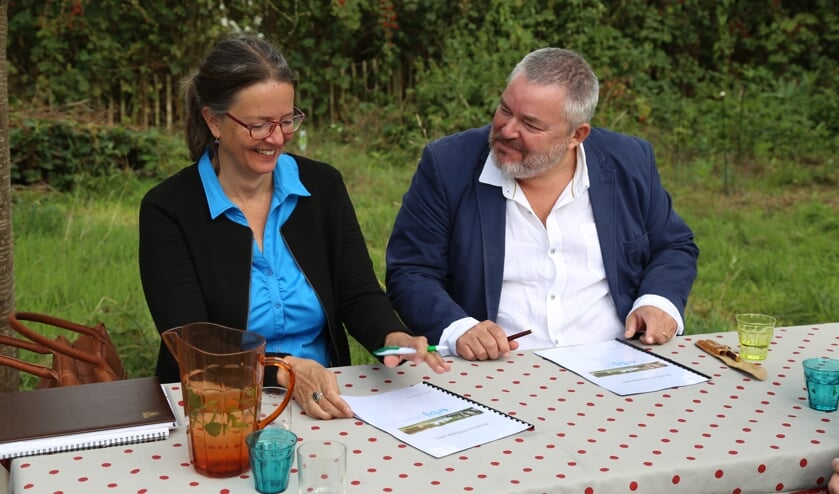 Patricia van Rooij (l.) van Kleine Aarde Netwerk en Rick Spooren van Erbij Dagbesteding ondertekenen de intentieverklaring. | Fotonummer: c5bb6f