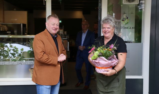 Ingrid van Veen neemt uit handen van wethouder Eric van den Broek een felicitatiegeschenk in ontvangst bij de opening van haar nieuwe zaak aan de Markt in Boxtel. | Fotonummer: f7e423