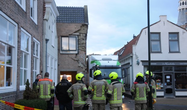 Hotelier en chauffeur bekijken samen met de brandweer de ravage.