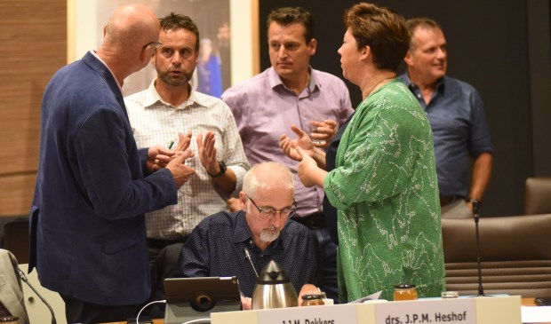 Beeld uit de bewuste raadsvergadering. Raadsleden van CDA, VVD en Pvda/GL in gesprek over de motie over de regenboogvlag. Jacques Dekkers (zittend) diende die in.