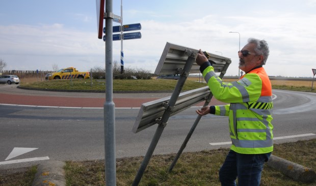Kantonnier Jan Rinses van de provincie raapt de borden op bij de rotonde in Poortvliet.