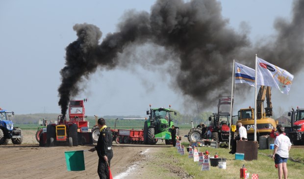 Zwarte rook kleurt de lucht boven het terrein van de trekkertrek.