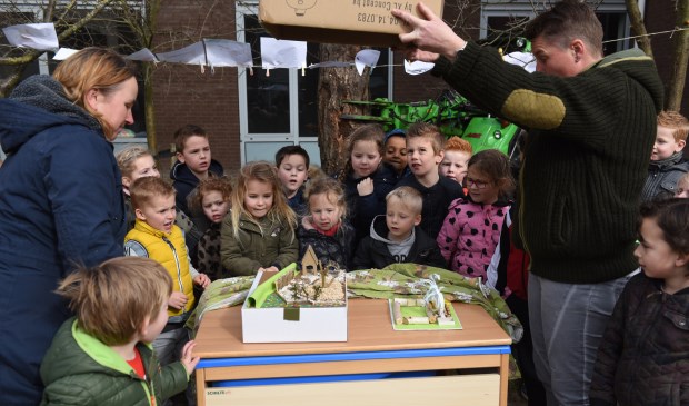 De kinderen kijken naar de zojuist onthulde maquette. Links juf Elly Dongen en rechts juf Anne-Mieke Reedijk.