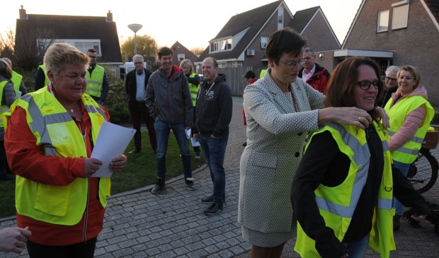 Burgemeester Van de Velde helpt een van de coördinatoren in een hesje.