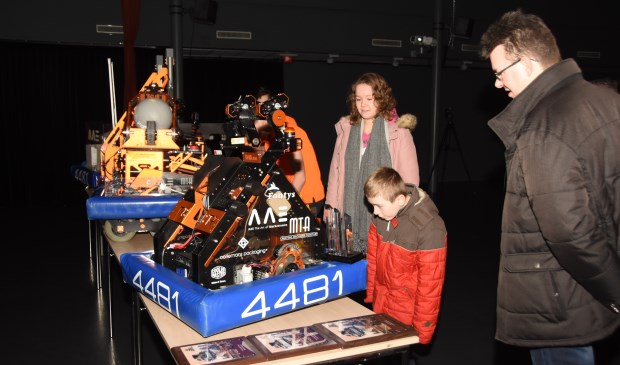 Familieleden vergapen zich aan de robots van eerdere jaren. | Fotonummer: e31d88