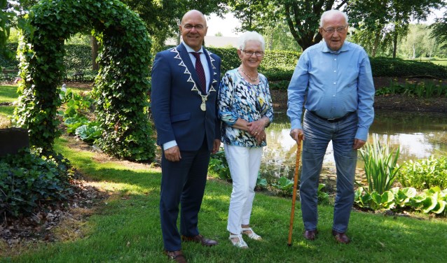 Riek en Theo van Genugten staan met burgemeester Van Rooij bij hun mooie vijver | Fotonummer: c11174