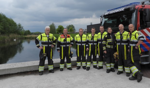 De brandweer net na het redden van de babyzwaan. Op de achtergrond zie je één van de twee volwassen zwanen. | Fotonummer: 2d8556