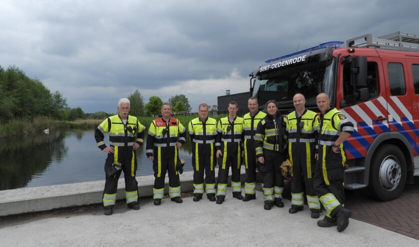 De brandweer net na het redden van de babyzwaan. Op de achtergrond zie je één van de twee volwassen zwanen. | Fotonummer: 2d8556