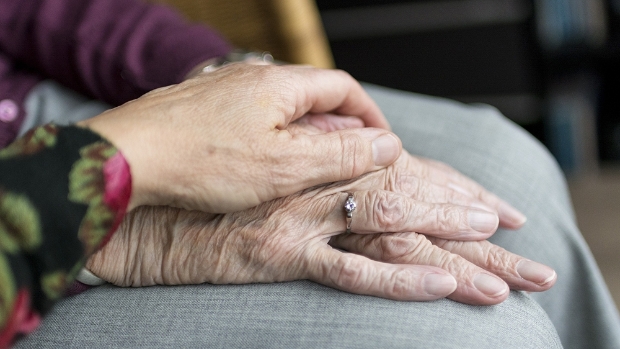 Oudere mensen houden elkaars hand vast