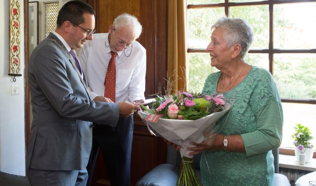 Een bloemetje en een kopie van de trouwakte voor het briljanten bruidspaar Corbet-Verhoeven.