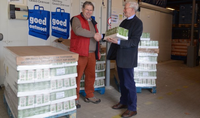 Martien Franken (rechts) overhandigt de koffie aan Jan den Ridder (links) van de Voedselbank.
