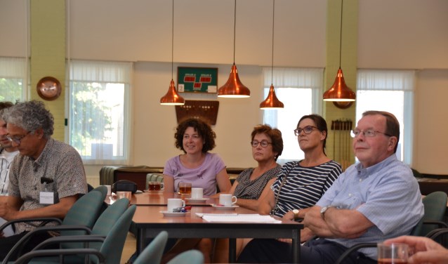 Bezoekers van de inloopavond over windmolens luisteren naar de uitleg van wethouder Andrew Harijgens.