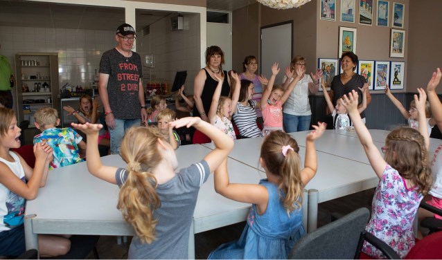 Kinderen van de plaatselijke basisschool hebben plezier bij de opening van het Participatiecafé.