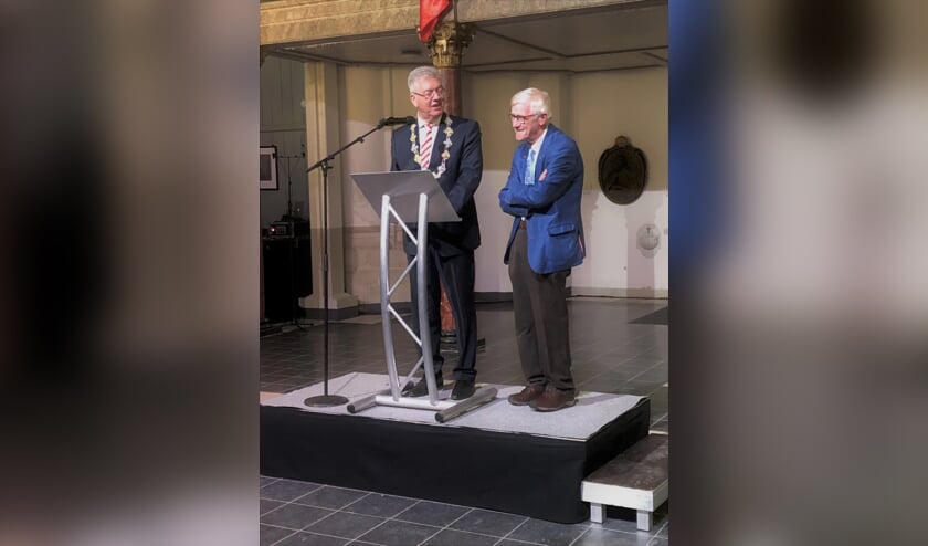 De heer Ferd Quik (rechts) ontvangt de erepenning met inscriptie van gemeente Bergen op Zoom uit handen van burgemeester dr. Frank Petter.