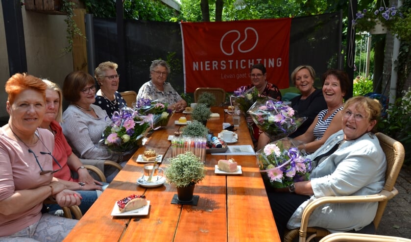 Jubilarissen met bloemen tussen anderen die de Nierstichting steunen.