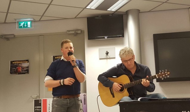 Stan van Hoof zingt tijdens zijn albumpresentatie op het Zwijsen afgelopen dinsdag. Muziekdocent meneer Van Hoof begeleidt hem op gitaar.
