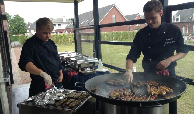 Mike Versantvoort (rechts) achter de barbecue.