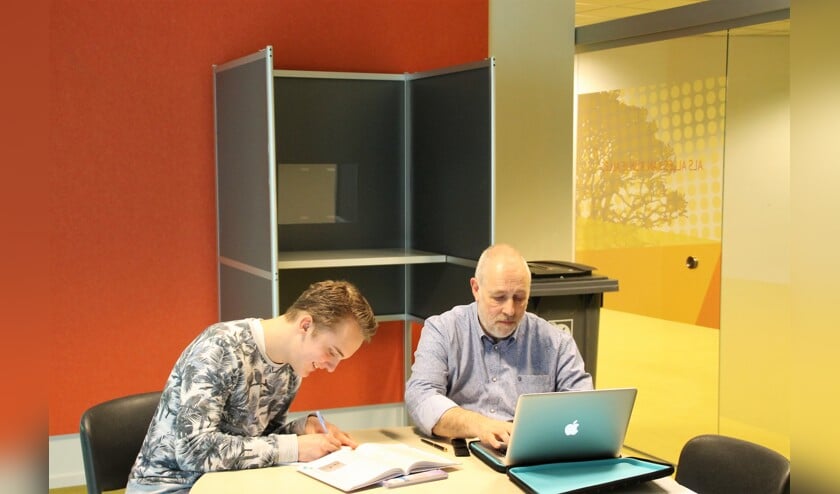 Achter Siets (havo 5) en Meneer Schenk (wiskundedocent) staat het stemhokje.