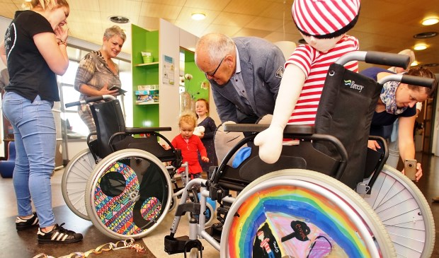 Jan van Raaij van Vrienden van het Maasziekenhuis kijkt goedkeurend naar een gepimpte rolstoel.