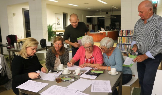Marion Vermeulen (tweede van links) en Wout Mulders van Mooiland (staande in het midden) helpen planten selecteren voor geveltuinen.
