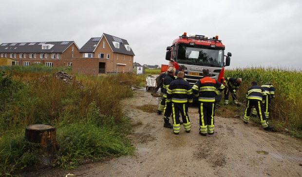 Brandweermannen werpen rondom de vrachtwagen een zanddijkje op. Foto: SK-Media