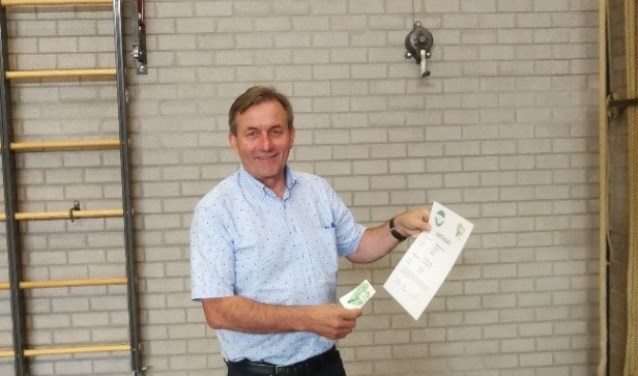 Sjaak van der Linden in de Rijkevoortse sportzaal met het Groen Certificaat.