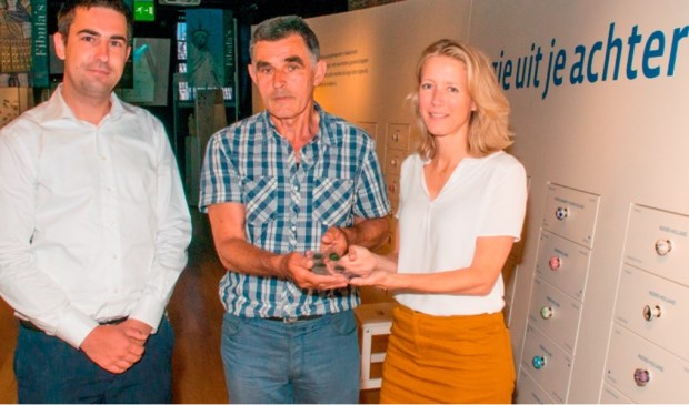 Jan Kusters en drs. Lenie van Esser, projectleider presentaties van het Stedelijk Leiden, met de muntschat. Links Felix van Ballegooij van de gemeente Sint Anthonis.